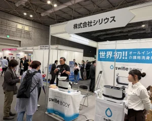 バリアフリー展2026の出展ブース。ベッド上で洗身可能な介護用洗浄製品のデモンストレーション。入浴機会の確保と介助者の負担軽減を両立する新技術。